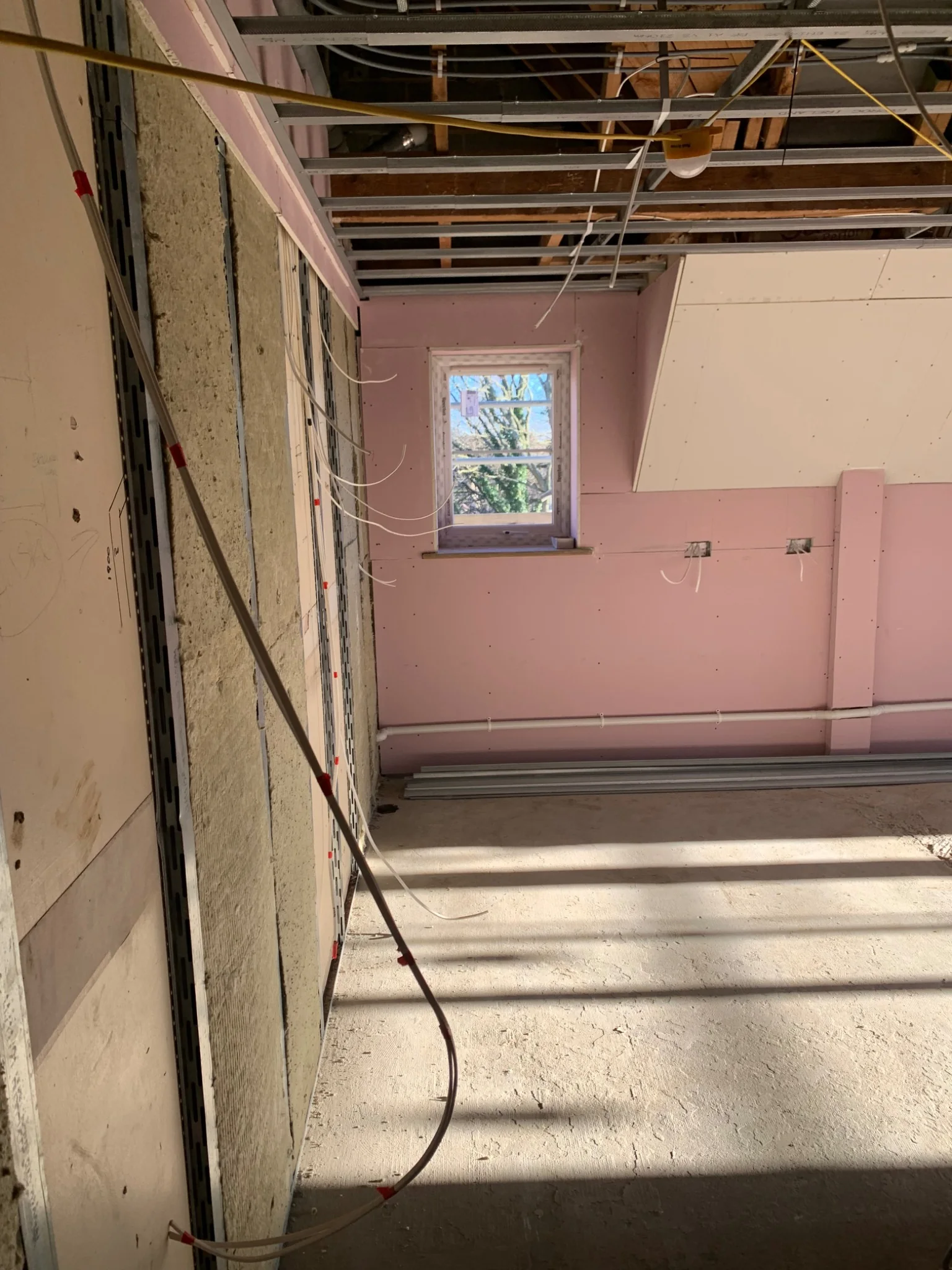 Acoustic insulation and ceiling construction being installed during an apartment conversion